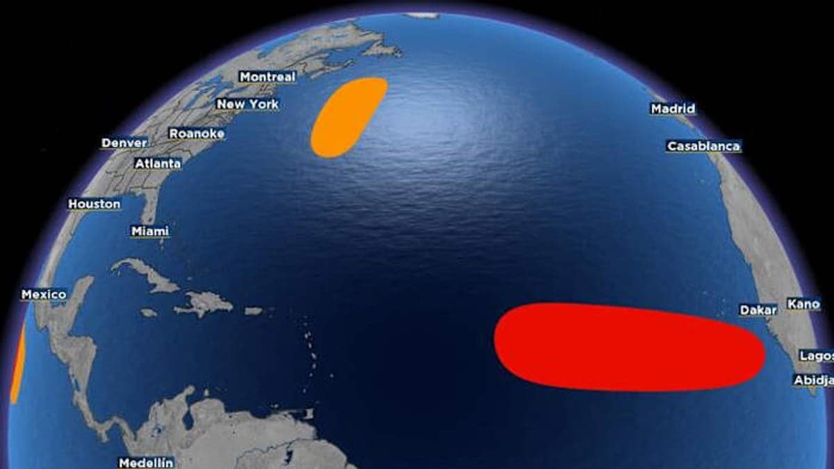 Imagem aérea do oceano Atlântico com céu claro e nuvens dispersas acima da água e ilhas tropicais ao longe