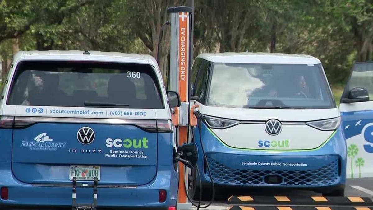 Ponto de ônibus suburbano com um ônibus de transporte público e pessoas aguardando sob céu azul e palmeiras, cenário urbano típico da Flórida.