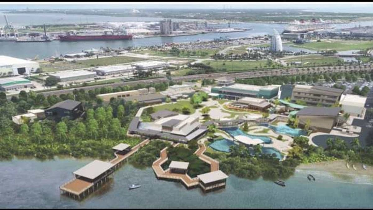 Vista ampla do Port Canaveral mostrando docas, água e prédios industriais sob céu azul