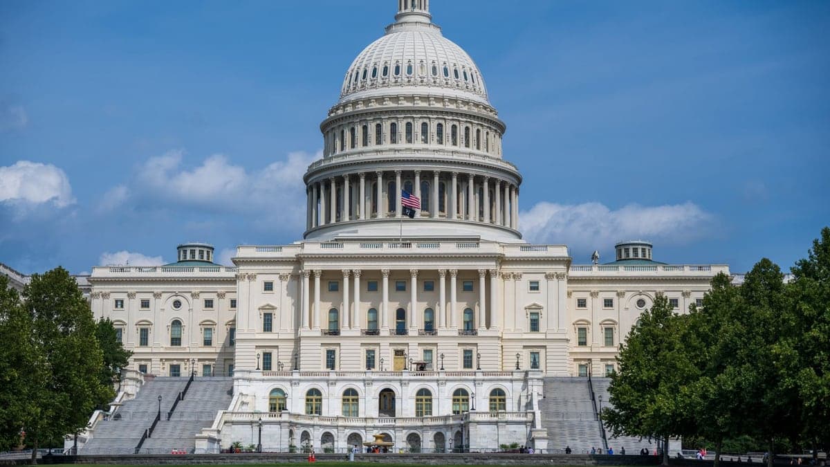 Fachada frontal do Capitólio dos Estados Unidos sob céu azul com poucas nuvens