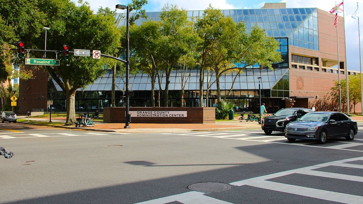 Prédio do Orange County Administration Center, um edifício governamental moderno com bandeiras e jardins na frente