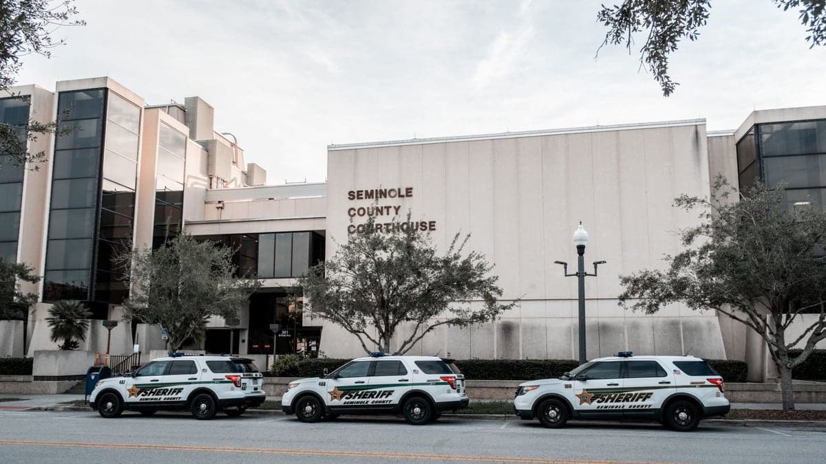 Fachada do prédio do tribunal do Condado de Seminole com três viaturas da polícia estacionadas em frente