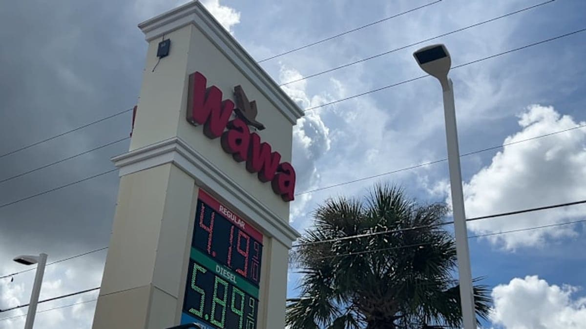 posto de gasolina em Orlando com bandeiras da estação, palmeiras ao fundo e céu azul