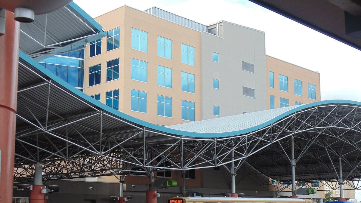Terminal de ônibus em Orlando com cobertura em estrutura metálica e ônibus da empresa Lynx estacionados.