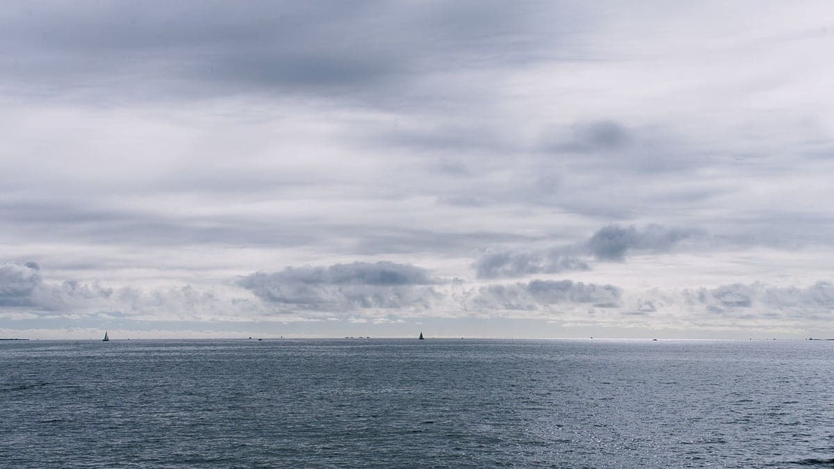 Vista do mar sob céu nublado com nuvens carregadas no horizonte