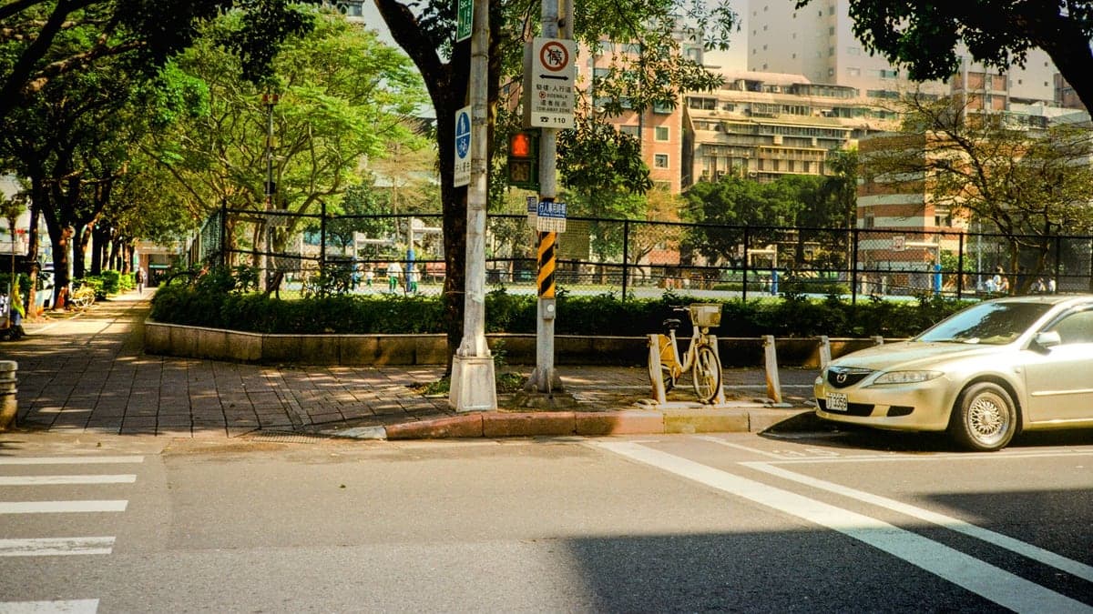 Rua com calçada arborizada, sem parquímetros visíveis, e carro estacionado em vaga ao lado da rua em área urbana de Orlando