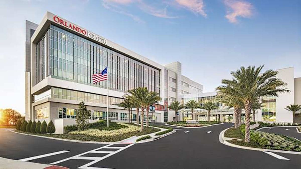 Fachada do South Lake Hospital Center for Women and Babies em Clermont, mostrando a entrada principal, estacionamento e palmeiras sob céu azul.