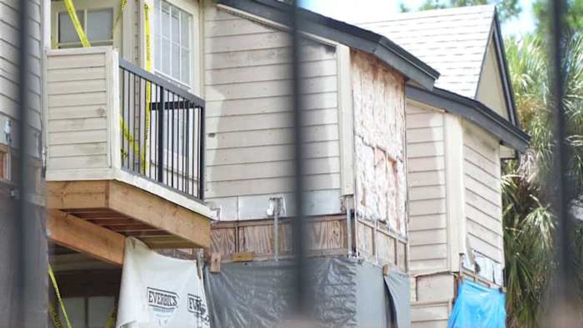 Vista externa de um prédio de condomínio de três andares em área residencial de Orlando, com palmeiras e sol forte típico da Flórida