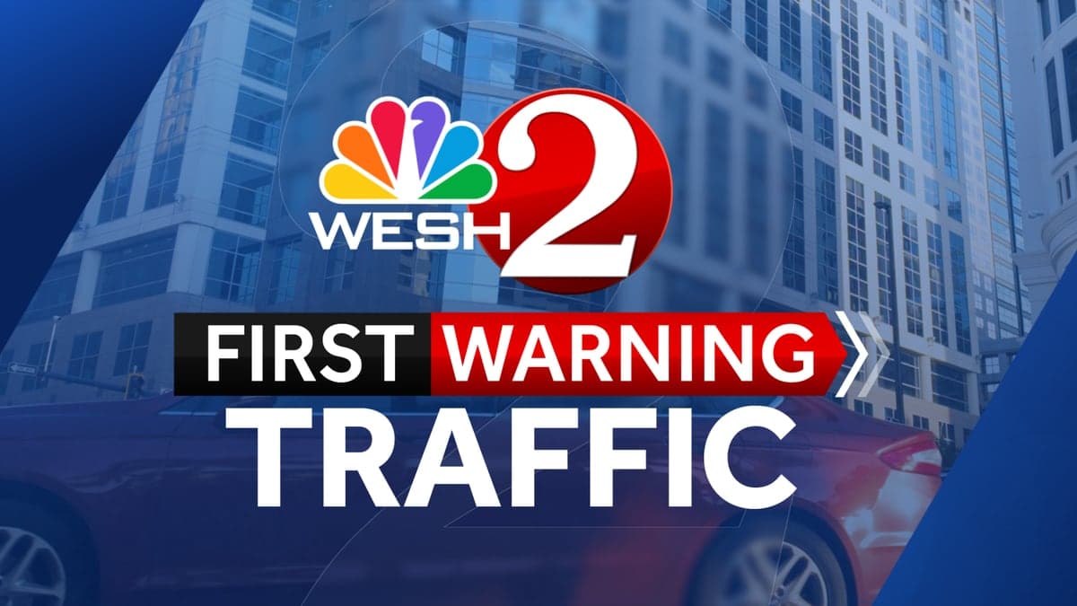 Vista da rodovia John Young Parkway em Orlando com pistas e palmeiras ao redor sob céu claro.