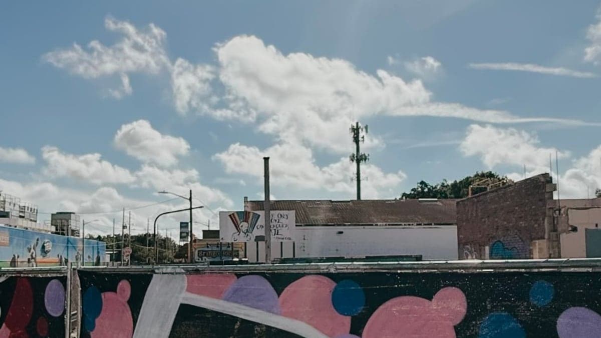 Fachada do Escritório Administrativo do Orlando Executive Airport com estacionamento e palmeiras ao redor sob céu claro